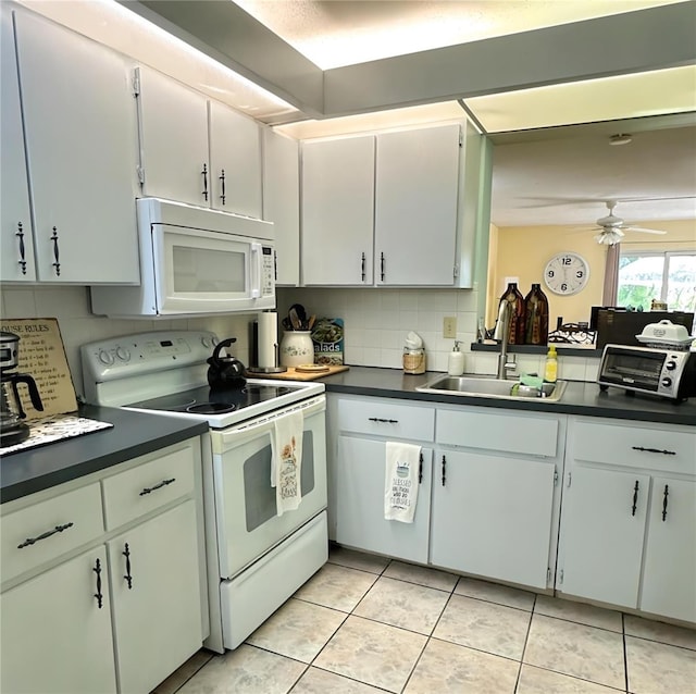 kitchen featuring a ceiling fan, a sink, backsplash, dark countertops, and white appliances