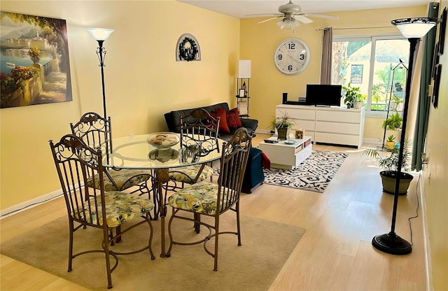 dining room featuring baseboards, a ceiling fan, and wood finished floors