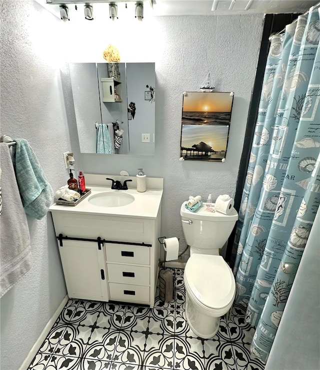 bathroom featuring vanity, a shower with shower curtain, tile patterned flooring, toilet, and a textured wall