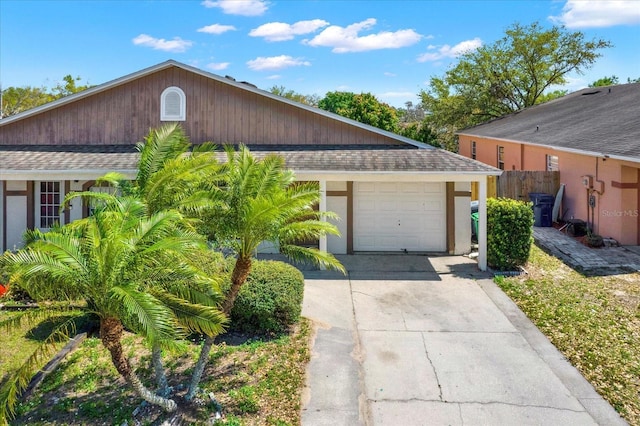 exterior space with stucco siding, fence, driveway, and a shingled roof