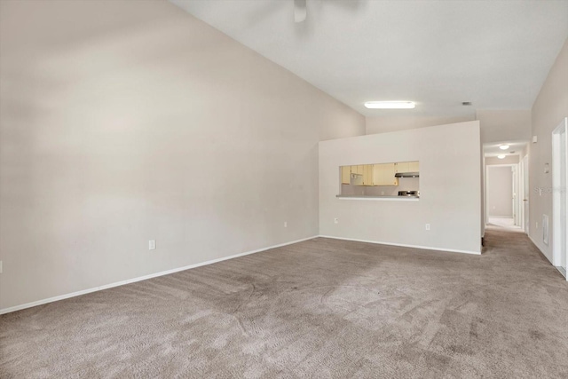 unfurnished living room featuring baseboards, carpet, and high vaulted ceiling