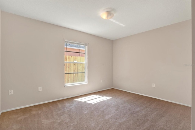 carpeted empty room with baseboards