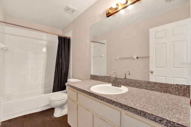 bathroom with visible vents, shower / bath combo with shower curtain, toilet, wood finished floors, and vanity