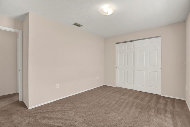 unfurnished bedroom featuring a closet, visible vents, carpet flooring, and baseboards