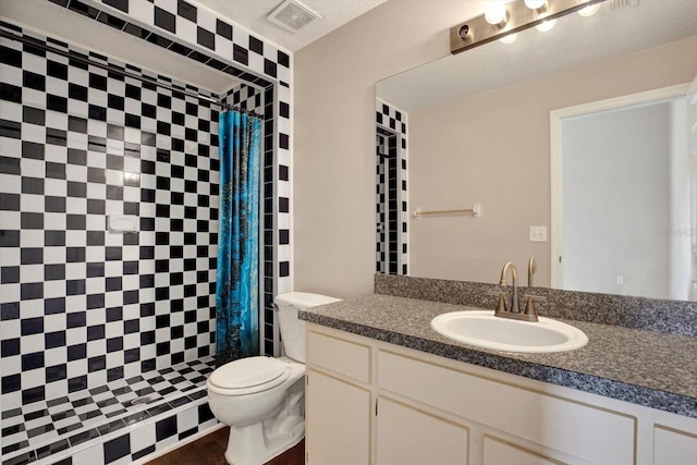 full bathroom featuring vanity, toilet, visible vents, and tiled shower