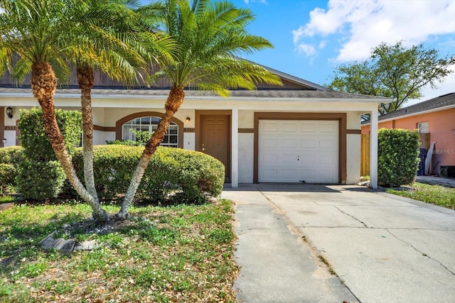 ranch-style house featuring an attached garage, driveway, and stucco siding