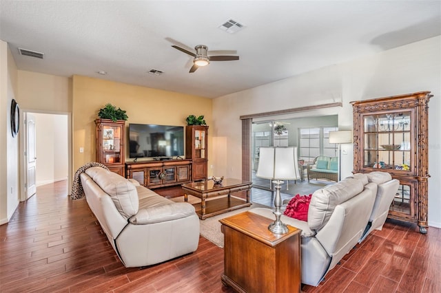 living room featuring a ceiling fan, dark wood-style floors, and visible vents