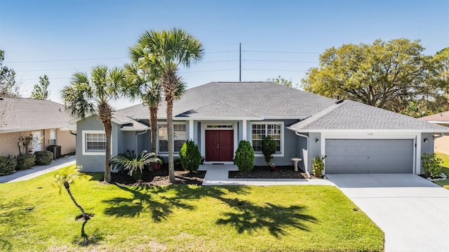 single story home with a front lawn, central air condition unit, an attached garage, and driveway