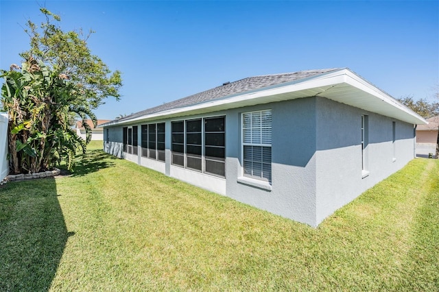 rear view of property with stucco siding and a lawn