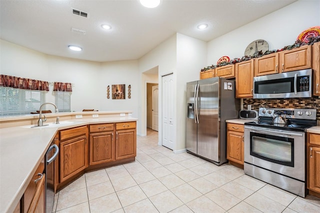 kitchen featuring a sink, visible vents, appliances with stainless steel finishes, and brown cabinetry