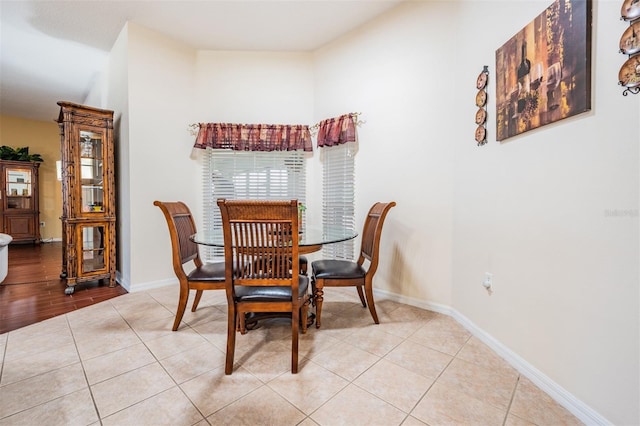 dining space with light tile patterned flooring, baseboards, and plenty of natural light