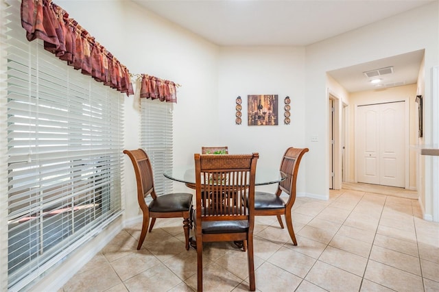 dining space with light tile patterned floors, visible vents, and baseboards