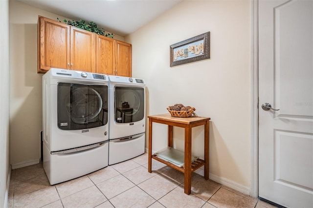 laundry room featuring light tile patterned floors, cabinet space, baseboards, and separate washer and dryer