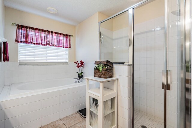 full bath with tile patterned floors, a garden tub, and a stall shower