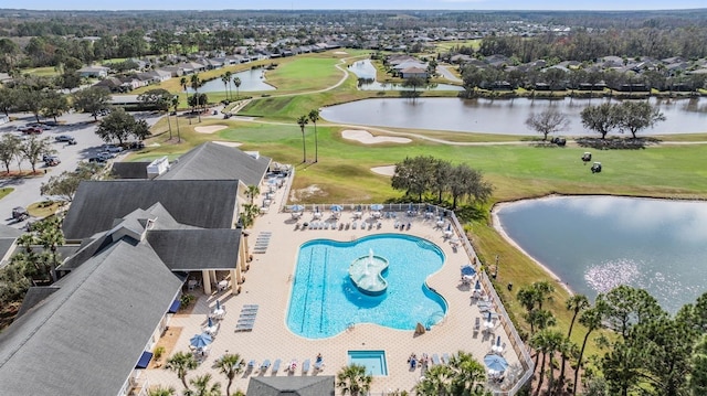 birds eye view of property with golf course view and a water view