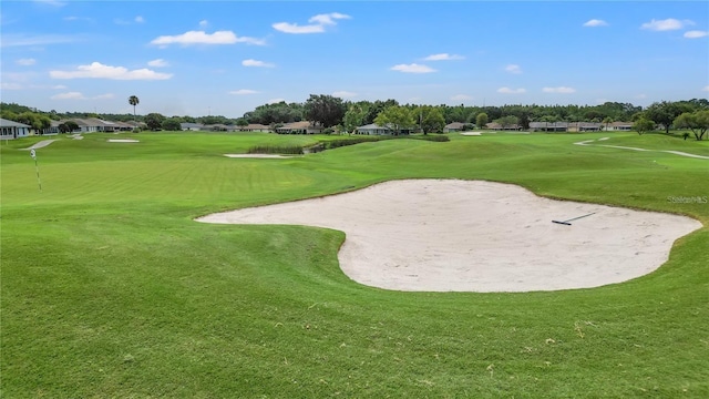 view of property's community featuring a yard and view of golf course