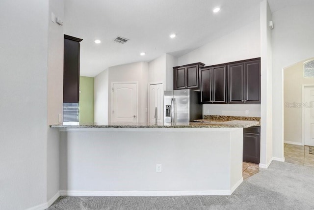 kitchen with visible vents, stone counters, light colored carpet, and stainless steel refrigerator with ice dispenser