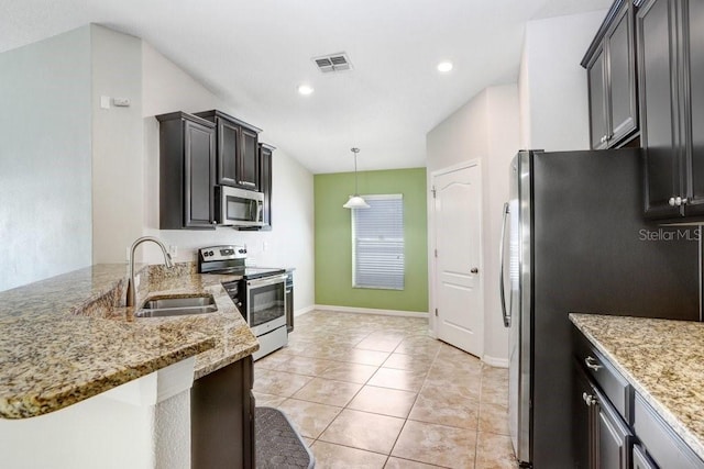 kitchen with visible vents, a sink, stainless steel appliances, light tile patterned flooring, and light stone countertops