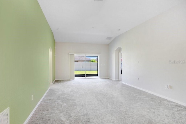 unfurnished room featuring baseboards, arched walkways, carpet, and visible vents