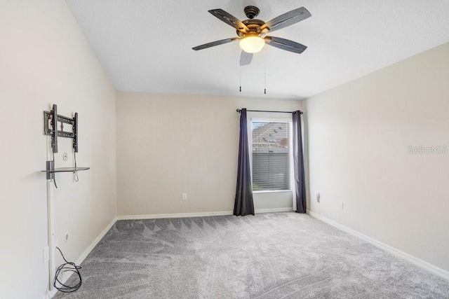 carpeted empty room featuring baseboards and ceiling fan