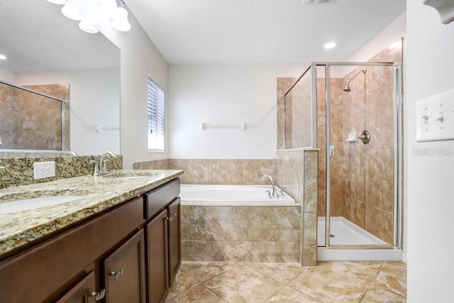 bathroom featuring a sink, a garden tub, a shower stall, and a textured ceiling