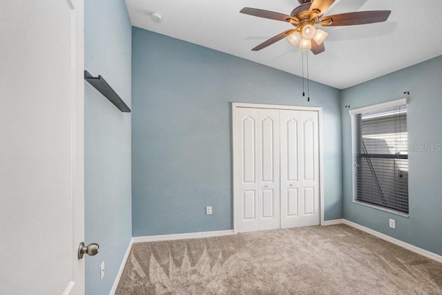 unfurnished bedroom with a closet, carpet flooring, ceiling fan, and baseboards