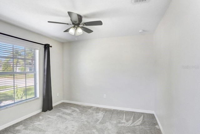 spare room with baseboards, light carpet, visible vents, and ceiling fan