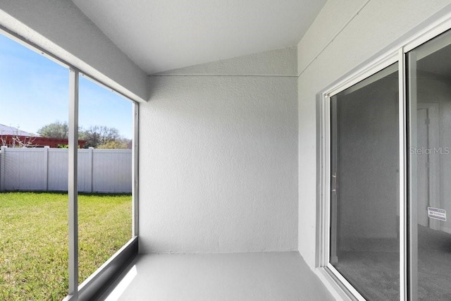 unfurnished sunroom featuring vaulted ceiling