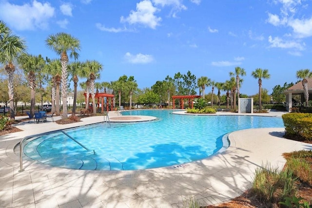 community pool with a patio area and a pergola