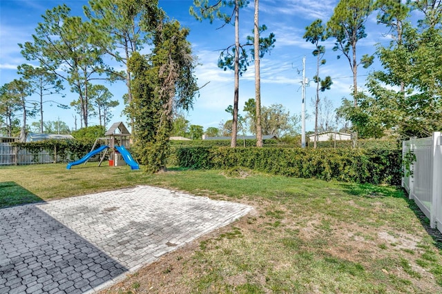 view of yard featuring a patio area, a playground, and a fenced backyard