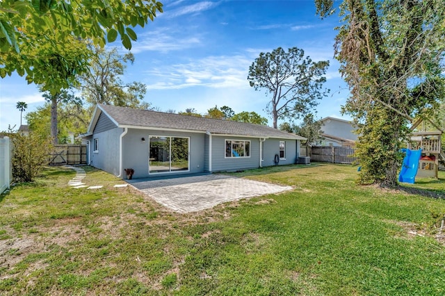 back of house featuring a yard, a fenced backyard, stucco siding, central air condition unit, and a patio area