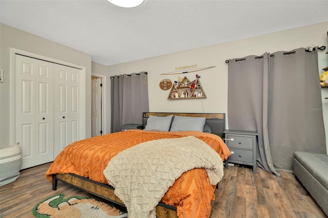 bedroom featuring wood finished floors, a closet, and a textured ceiling