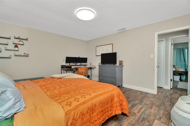 bedroom featuring visible vents, baseboards, a textured ceiling, and dark wood-style flooring