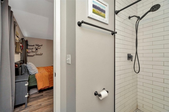 bathroom featuring a tile shower and wood finished floors