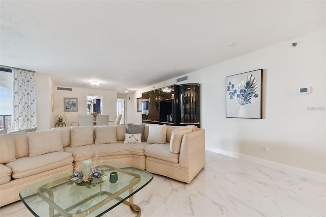 living room with baseboards, visible vents, and marble finish floor