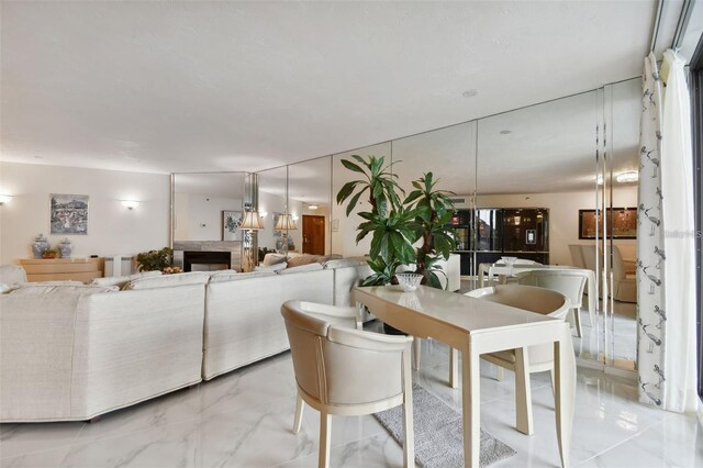 dining room with a fireplace and marble finish floor