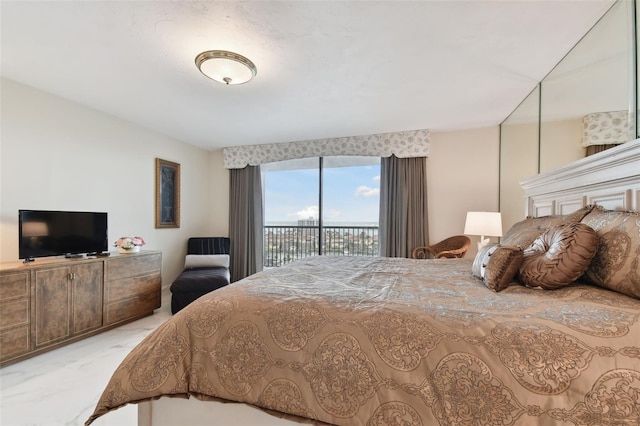 bedroom with marble finish floor and access to outside