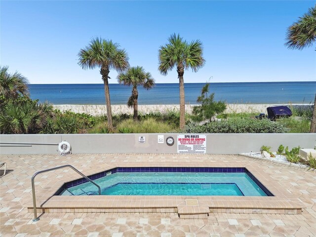 view of swimming pool featuring a swimming pool, a water view, and a patio area