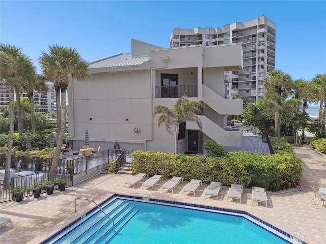 pool with a patio area and fence