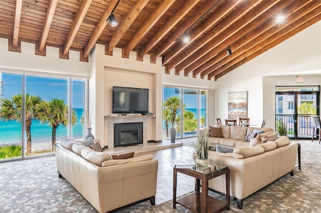 living area with a healthy amount of sunlight, beamed ceiling, wooden ceiling, a fireplace, and high vaulted ceiling