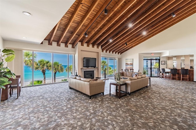 living room with carpet floors, high vaulted ceiling, beam ceiling, a glass covered fireplace, and wooden ceiling