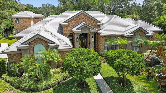 view of front of home featuring a tiled roof and brick siding