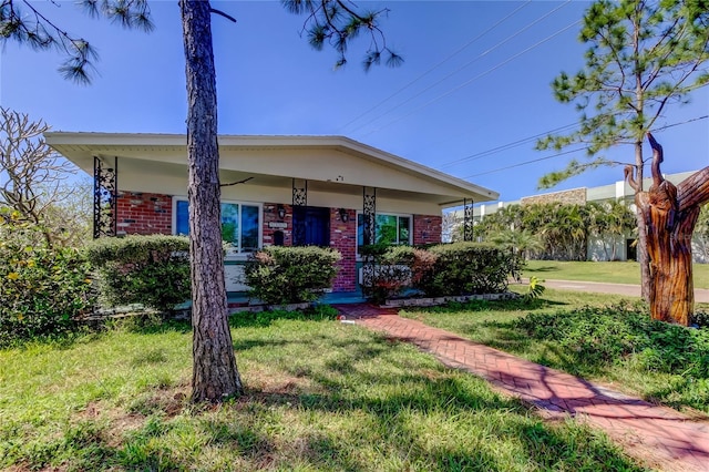 view of front of property with brick siding and a front lawn