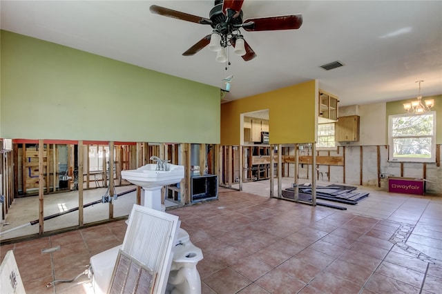 interior space with visible vents and ceiling fan with notable chandelier