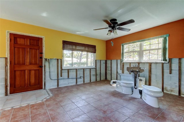 bathroom featuring tile patterned flooring, toilet, wainscoting, and ceiling fan