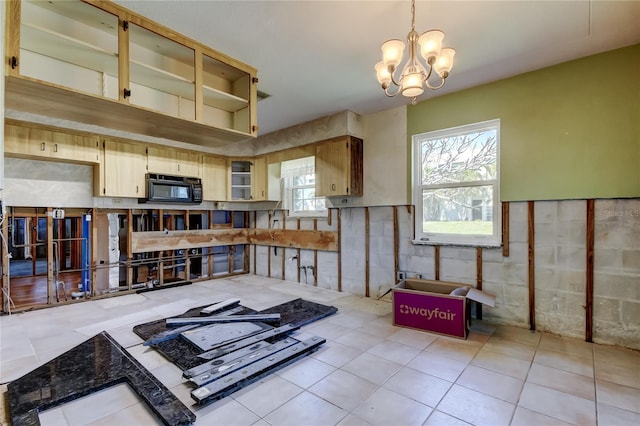 kitchen with a chandelier, light tile patterned floors, black microwave, and decorative light fixtures