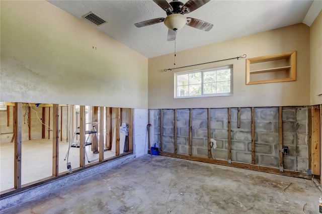 interior space featuring visible vents, unfinished concrete floors, and ceiling fan