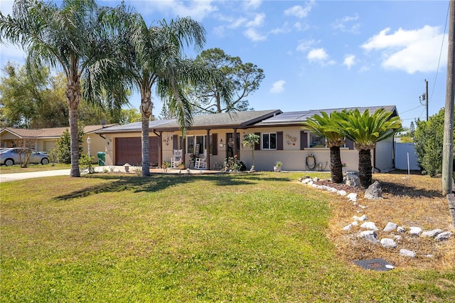 ranch-style house featuring driveway, an attached garage, solar panels, and a front lawn