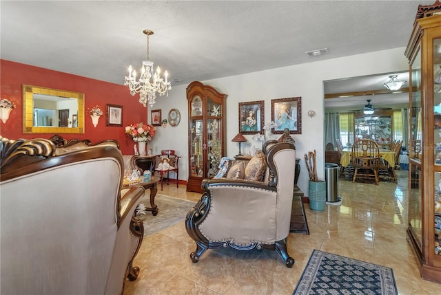 living area featuring visible vents, ceiling fan with notable chandelier, and a textured ceiling