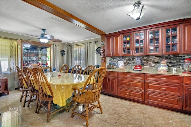 dining room featuring ceiling fan, visible vents, and a textured ceiling